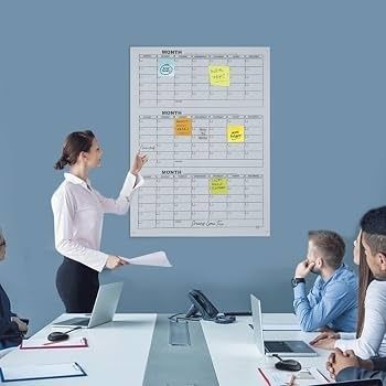 Kvinna presenterar en kvartalsplan med månadstavlor för ett team